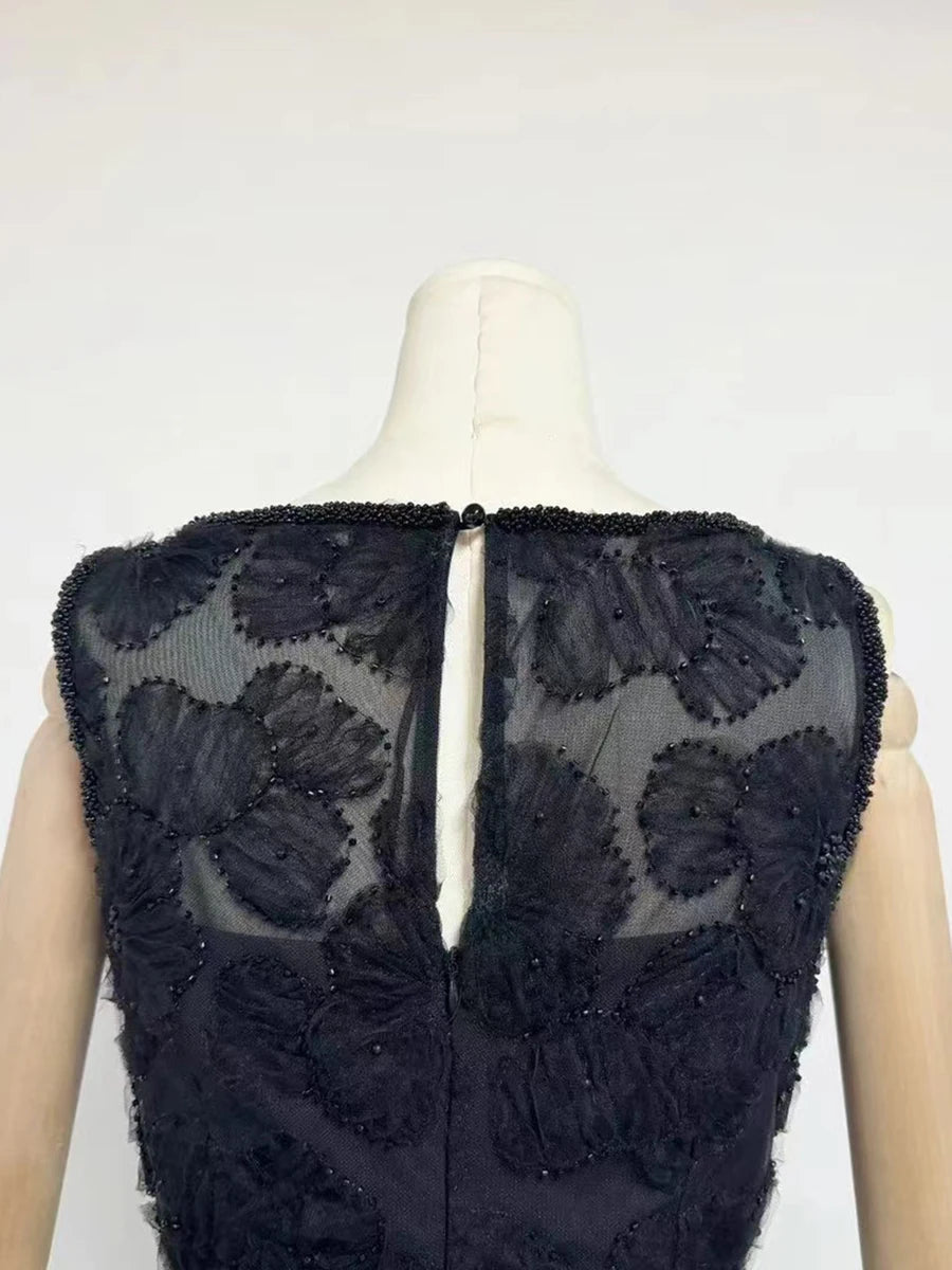 Black embroidered dress on a mannequin against a white background