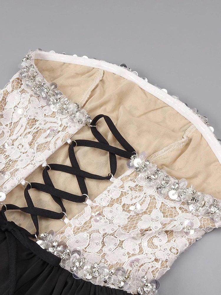 Close-up of a lace garment with black straps on a gray background