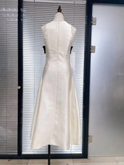 White dress on a mannequin against a glass door.