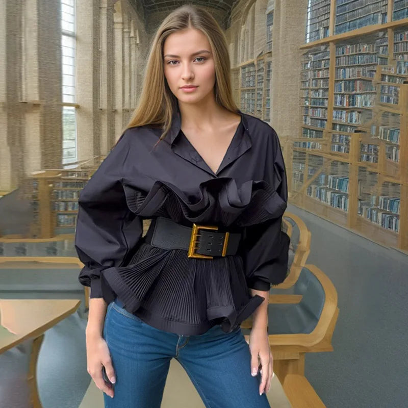 Woman wearing a black blouse with ruffles and a belt in a library setting