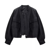 Black cropped faux leather jacket with round neck and dual front pockets.