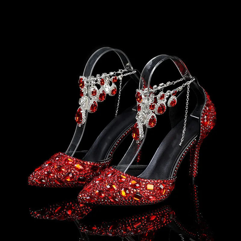 Red high-heeled shoes with gemstone embellishments on a black background