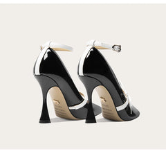 Black high-heeled shoes with white accents on a light gray background