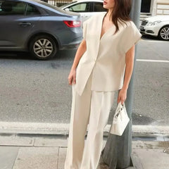 Woman in a white outfit standing on a street with cars in the background