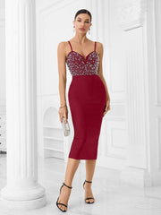 Woman wearing a red dress with a beaded top in a white room.