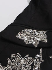 Black fabric with silver butterfly sequin embellishments on a white background