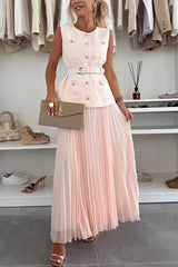 Woman wearing a light pink dress with a matching clutch in a clothing store.