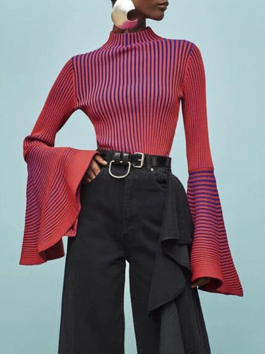 Person wearing a red and purple striped top with black pants on a light blue background