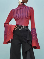 Person wearing a red and purple striped top with black pants on a light blue background