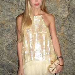 Woman wearing a sparkly dress against a stone wall