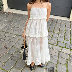 Back view of a person wearing a sheer mesh midi dress with floral lace