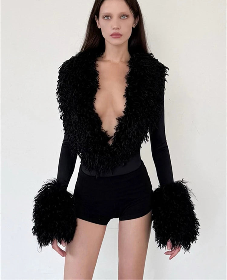 Black long sleeve top with black faux fur trim and cuffs, paired with black shorts.