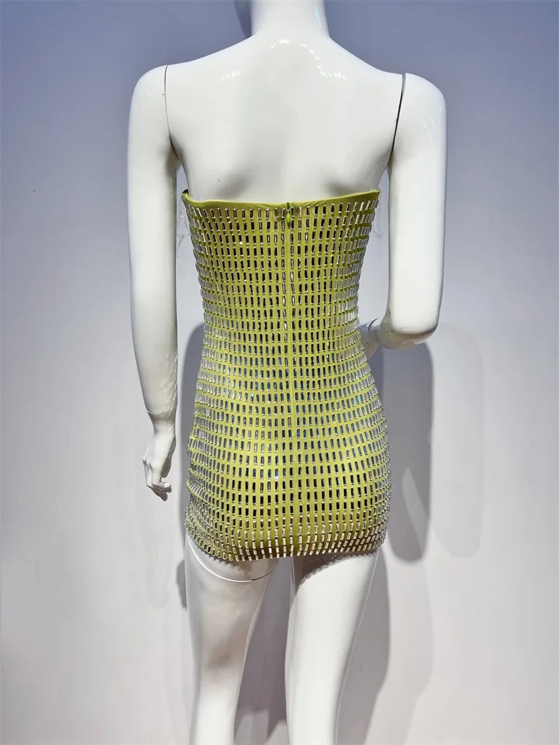Mannequin wearing a yellow dress with a unique mesh design on a gray background