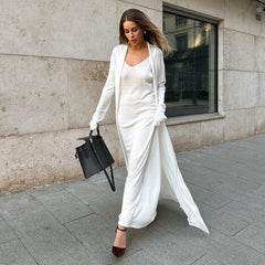 Woman in a white outfit walking on a city street.