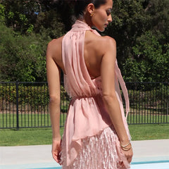 Woman wearing a pink dress with a sequin skirt by a poolside.