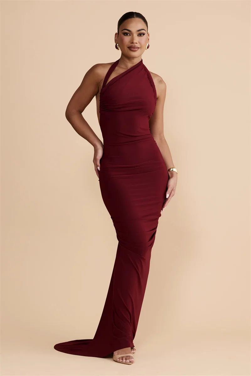 Woman wearing a burgundy halter neck gown on a beige background