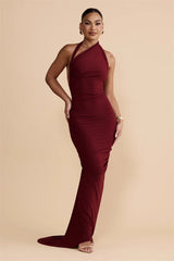 Woman wearing a burgundy halter neck gown on a beige background