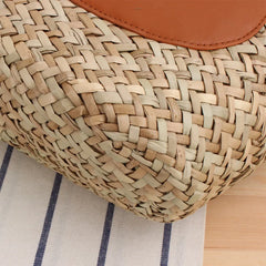 Close-up of a woven basket with a brown leather patch on a striped fabric background