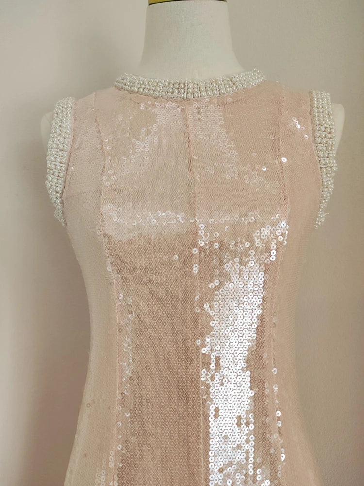 Mannequin wearing a beige sequin dress with a beaded neckline against a neutral background
