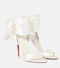 Pair of white satin stiletto heels with large bow ankle straps