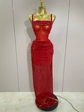 Red beaded evening gown on a mannequin against a plain background