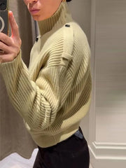 Person wearing a light green sweater taking a mirror selfie.