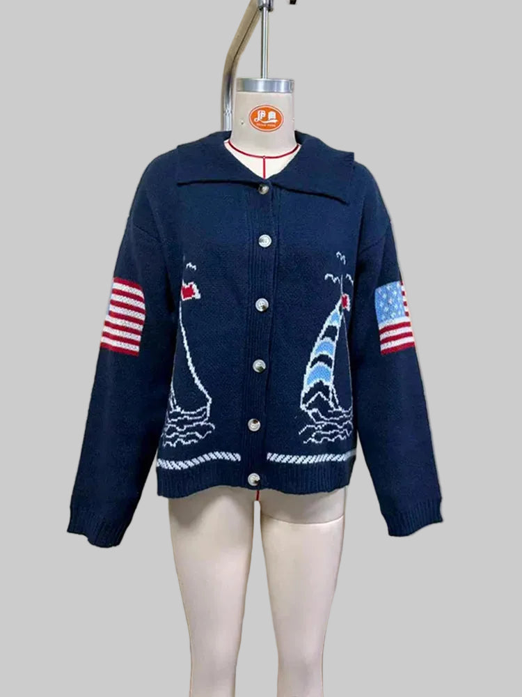 Mannequin displaying navy blue intarsia knit coat with sailboat pattern