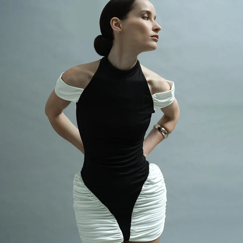 Woman wearing a black and white outfit against a gray background
