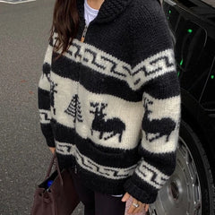 Person wearing a black and white patterned sweater with deer designs, standing next to a car.