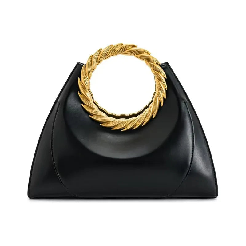 Front view of a black structured handbag with a gold ring handle