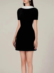 Black dress with white collar on a neutral background