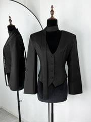 Black suit jacket and waistcoat on mannequins against a white background