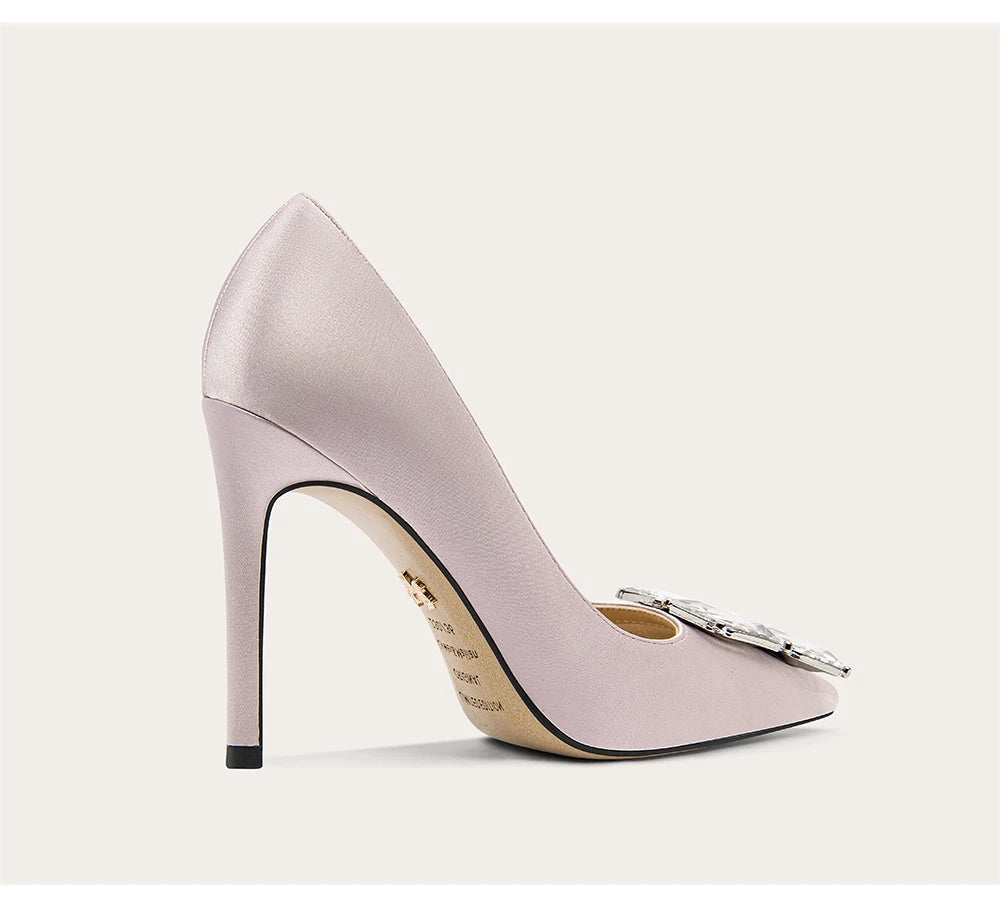 Pink high-heeled shoe with a decorative bow on a white background