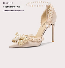 Elegant high-heeled shoe with floral and pearl details on a white background