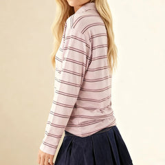 Person wearing a pink and white striped long-sleeve shirt with a beige background