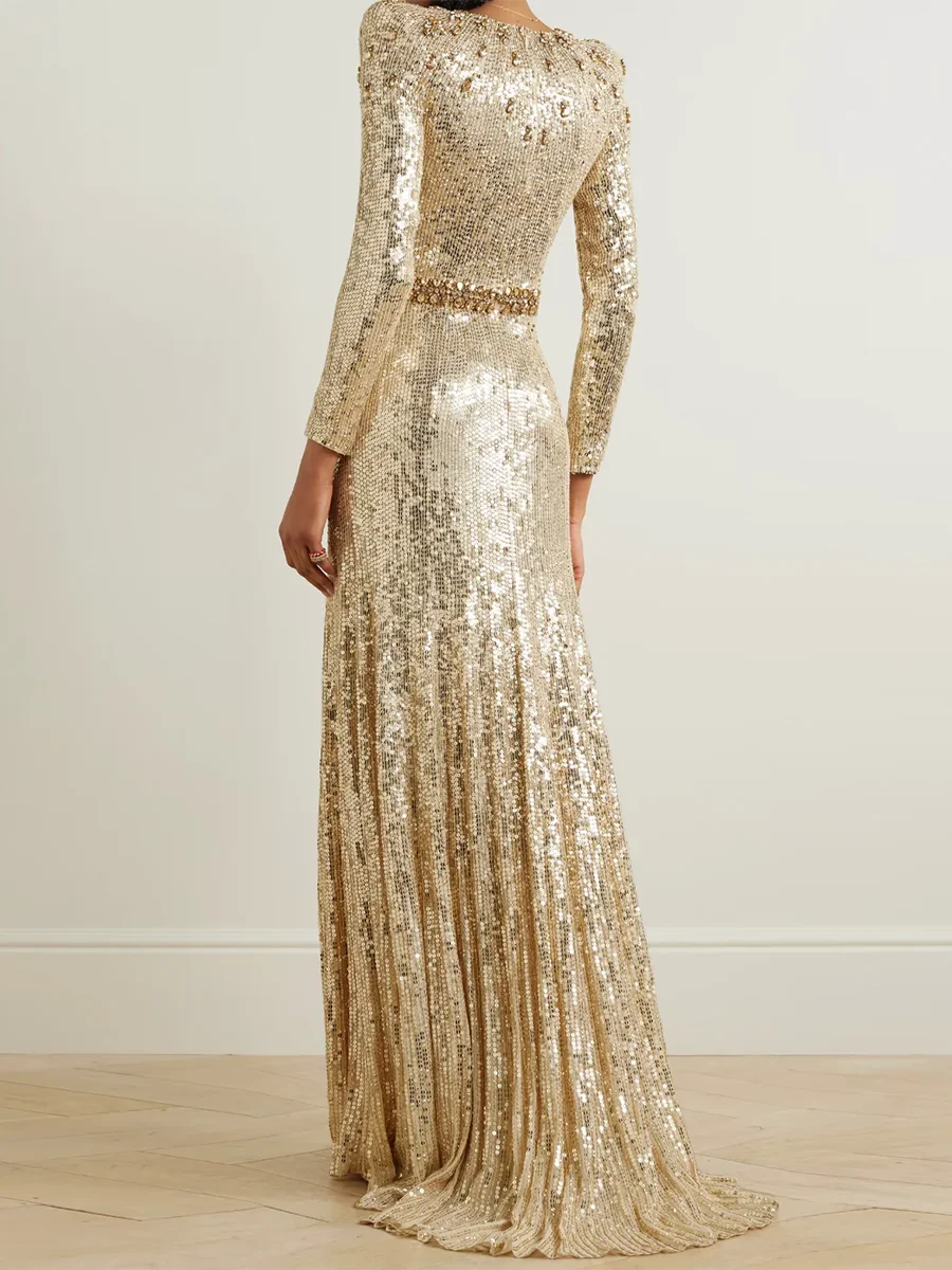Gold sequin evening gown with long sleeves on a plain background
