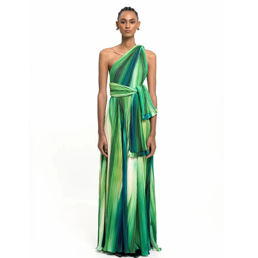 Woman wearing a one-shoulder pleated maxi skirt and bodysuit set with an abstract print.