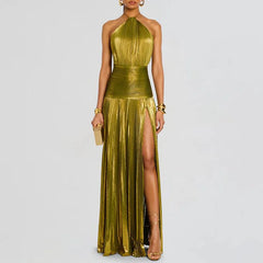 Woman wearing a gold  green halter neck gown with a slit on a light gray background
