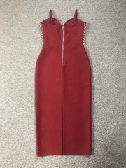 Red dress with embellishments on straps laid flat on a textured surface