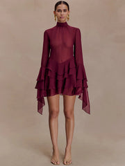 Maroon dress with ruffled layers on a beige background