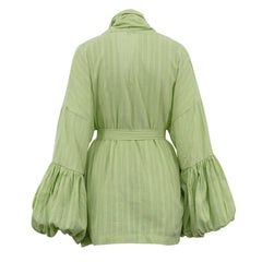 Green dress with ruffled sleeves on a white background