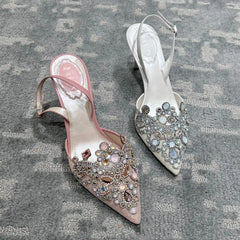 Pair of embellished high-heeled shoes on a textured surface