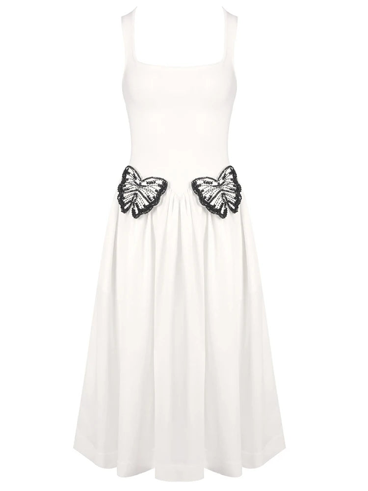 White dress with black butterfly embellishments on a white background