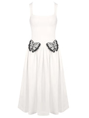 White dress with black butterfly embellishments on a white background