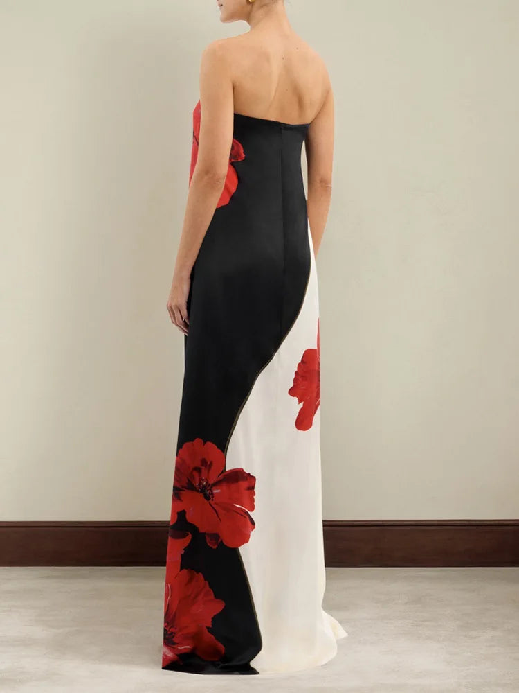 Woman wearing a black and white evening gown with red floral patterns.
