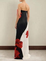 Woman wearing a black and white evening gown with red floral patterns.
