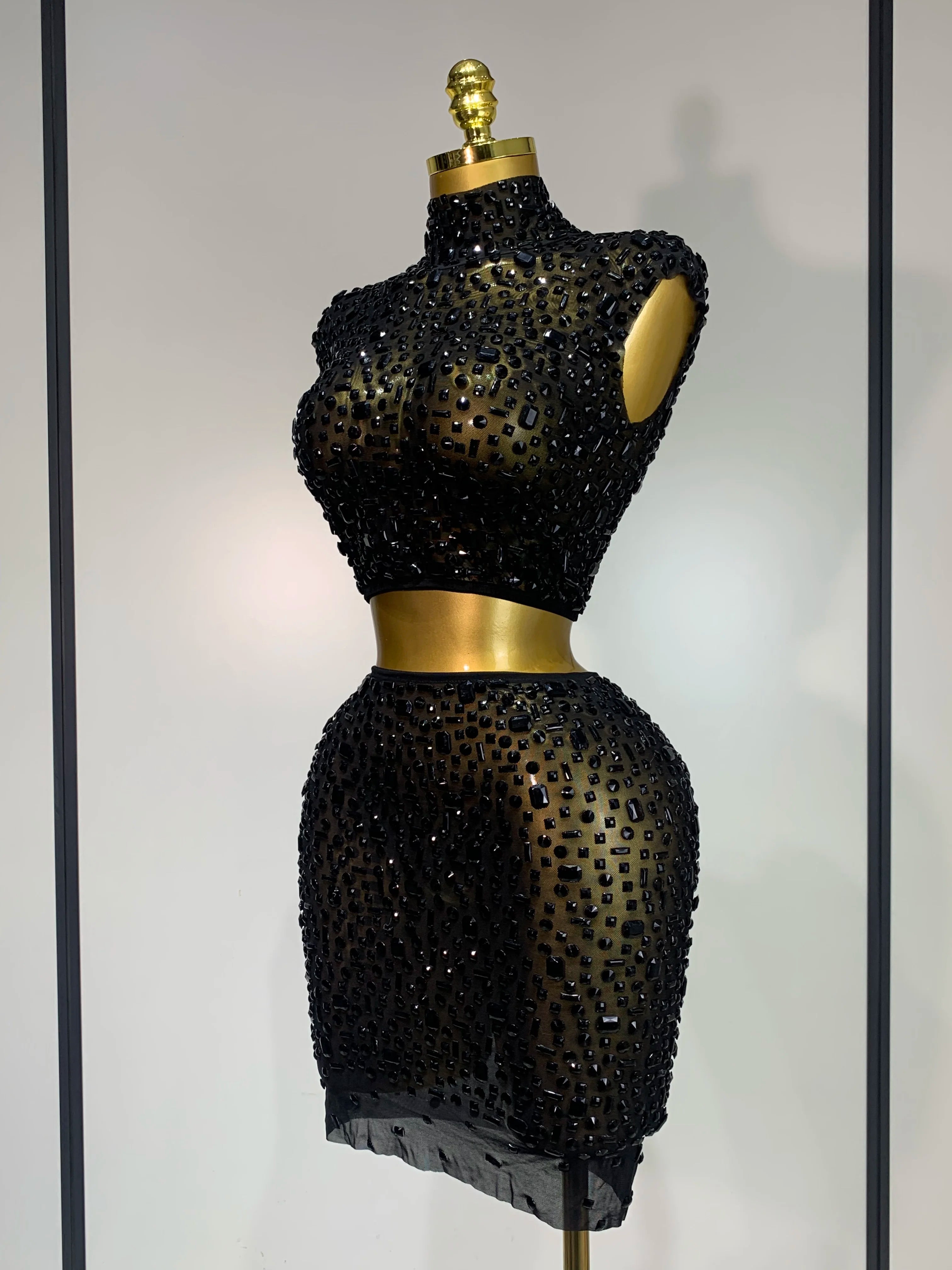 Black beaded dress on a mannequin against a neutral background