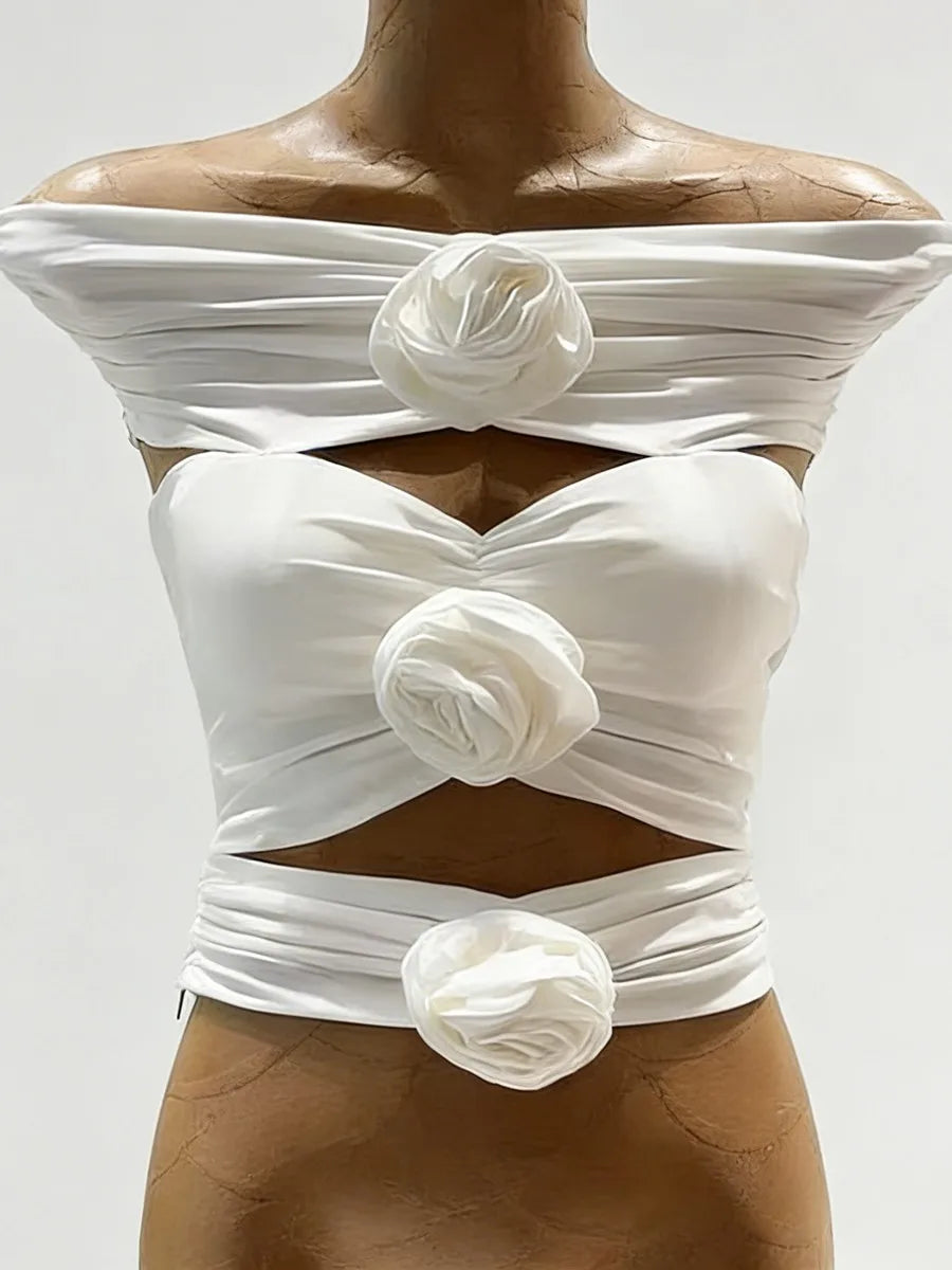 White off-shoulder top with floral embellishments on a mannequin against a white background