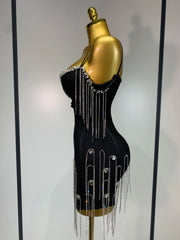Black dress with silver fringe and embellishments on a mannequin against a white background