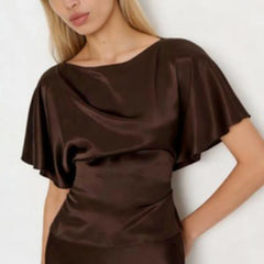 Woman wearing a brown satin dress against a white background